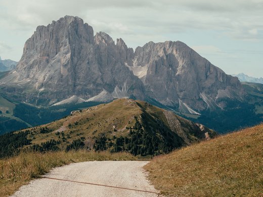 Inklusivleistungen – last minute nach Südtirol Wanderweg mit Bergkulisse und bewölktem Himmel