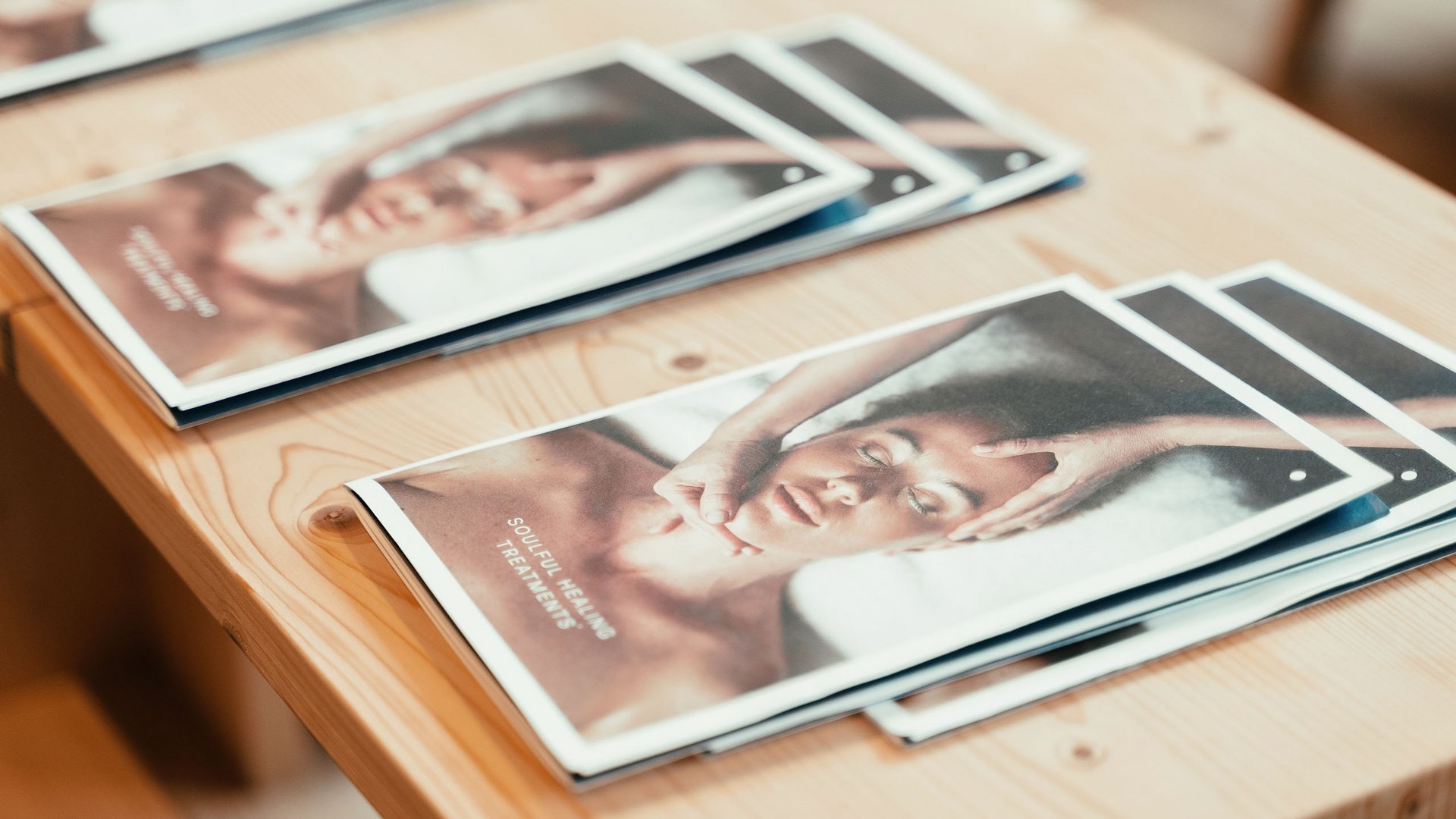 Day Spa in Südtirol – Wellness für die Seele Flyer über Massage und heilende Behandlungen auf einem Holztisch