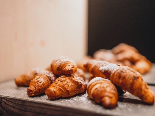 Inklusivleistungen – last minute nach Südtirol Frische Croissants auf einem Tablett mit Puderzucker bestreut