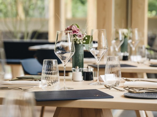 Wellness Aphrodite: Sensoria Dolomites among the winners Elegant dining table set with wine glasses and floral centerpiece