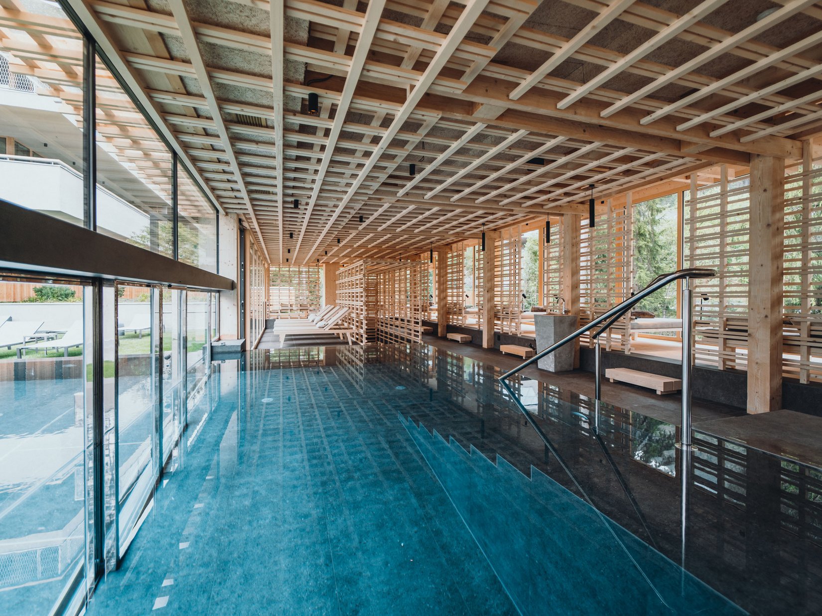 Luxury for the Soul: your adults-only hotel in the Dolomites Modern indoor pool with wooden beams and loungers in a spa