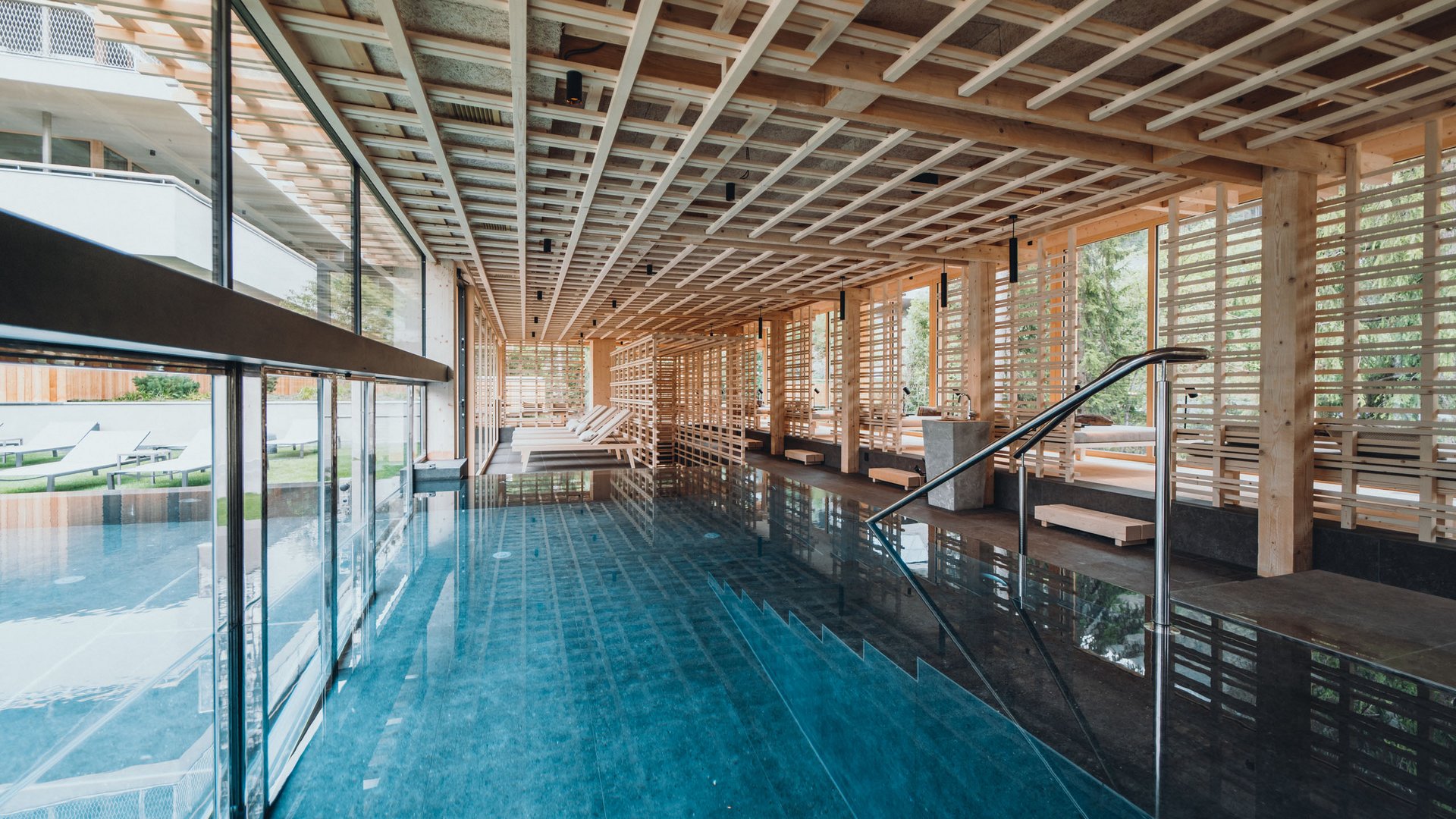 From hiking on Alpe di Siusi/Seiser Alm to the spa area Modern indoor pool with wooden beams and loungers in a spa