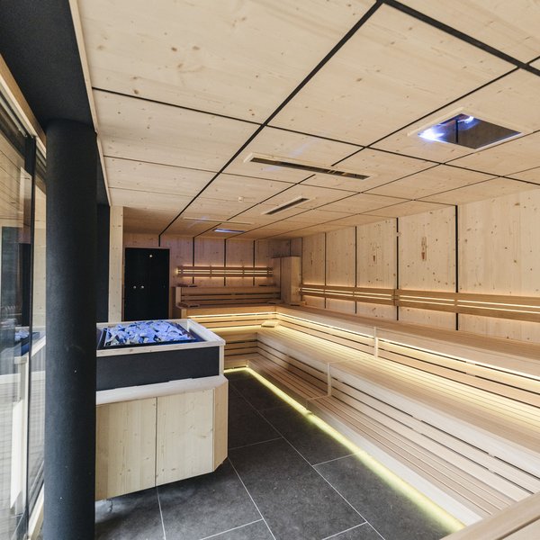 Sensoria Dolomites: Wellnesshotel in den Dolomiten Moderne, helle Sauna mit Holzbänken und Steinofen