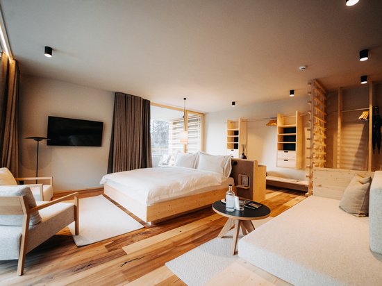 Sensoria: Private Spa Suite mit Whirlpool in Südtirol Modernes Hotelzimmer mit Holzmöbeln und gemütlichem Bett.