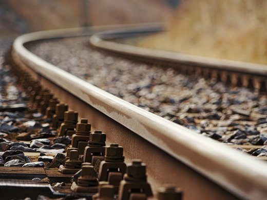 How to reach your getaway on Alpe di Siusi in South Tyrol Close-up of curved railway tracks with fasteners