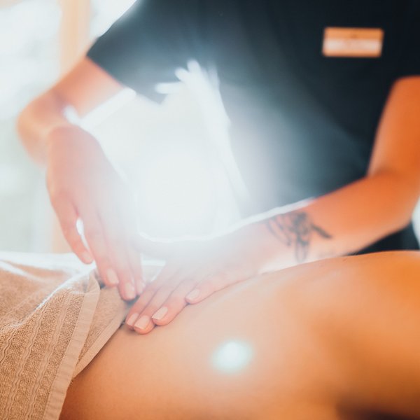 Sensoria Dolomites: Babymoon in Südtirol Person erhält sanfte Bauchmassage in hellem Raum