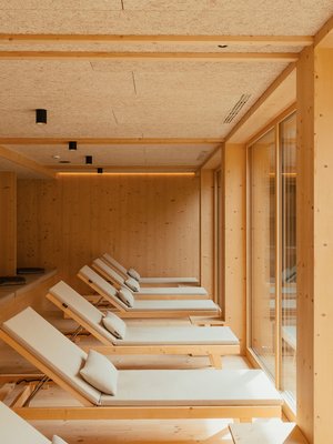 Sensoria Dolomites: Wellnesshotel in den Dolomiten Holzraum mit Liegestühlen und großen Fenstern zum Garten