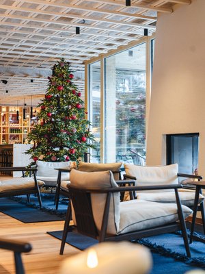 Sensoria Dolomites: il vostro hotel sull’Alpe di Siusi Area salotto accogliente con albero di Natale e camino in ambiente moderno