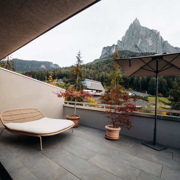 Sensoria: Private Spa Suite mit Whirlpool in Südtirol Terrasse mit Stuhl, Sonnenschirm und Bergblick bei bewölktem Wetter