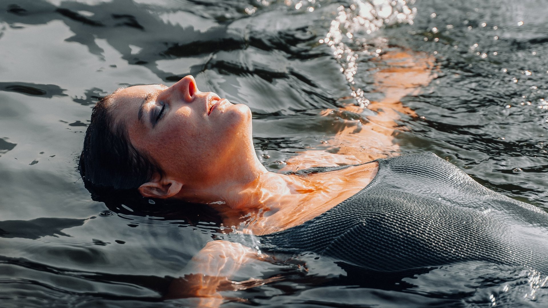 Frau entspannt beim Schwimmen und treibt auf dem Wasser
