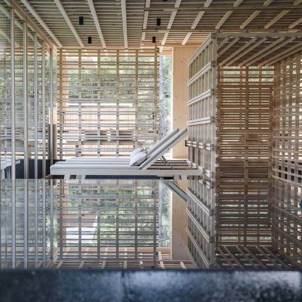 Sensoria Dolomites: Wellnesshotel in den Dolomiten Moderne Relax-Liegen in einem natürlichen Spa-Bereich mit Holz und Wasserreflexionen