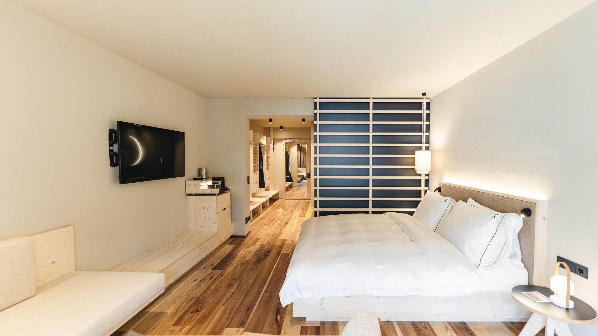 Dormire a Siusi allo Sciliar: la vostra camera preferita Camera d'albergo moderna con letto grande, pavimento in legno e TV a parete