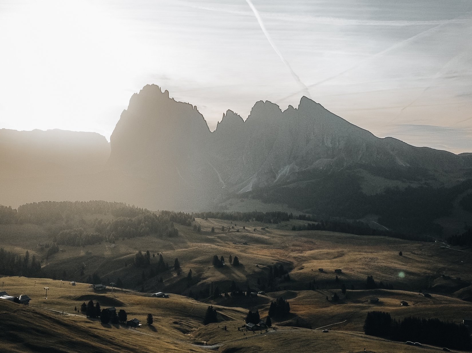 Offers – holidays in the Dolomites UNESCO World Heritage Person with raised arms on hill overlooking mountains at sunset