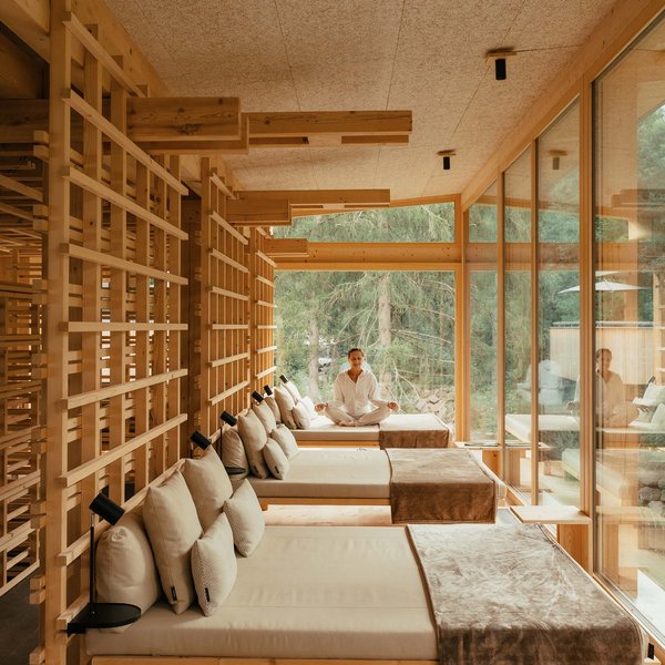 From hiking on Alpe di Siusi/Seiser Alm to the spa area Person meditating in modern wooden room with lounge beds and large windows