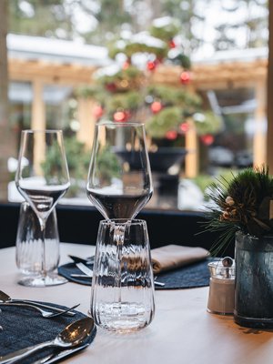 Luoghi energetici e apoteosi di gusto: Ristorante Anima Bicchieri da vino e posate su tavola apparecchiata con albero di Natale sullo sfondo