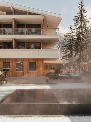 Sensoria Dolomites: il vostro hotel sull’Alpe di Siusi Edificio moderno con piscina esterna riscaldata e paesaggio innevato