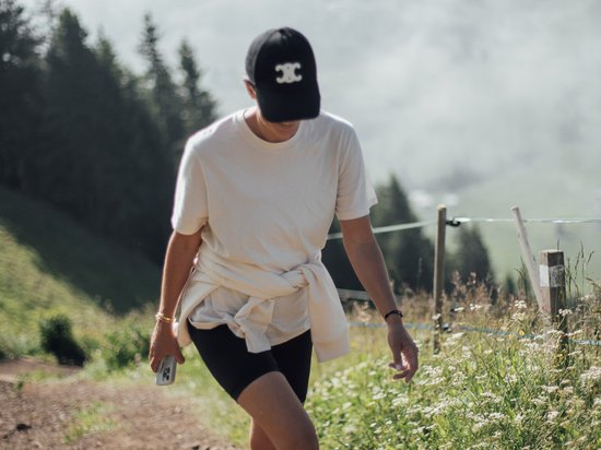 Offers – holidays in the Dolomites UNESCO World Heritage Person hiking on a mountain trail with fog and trees in the background
