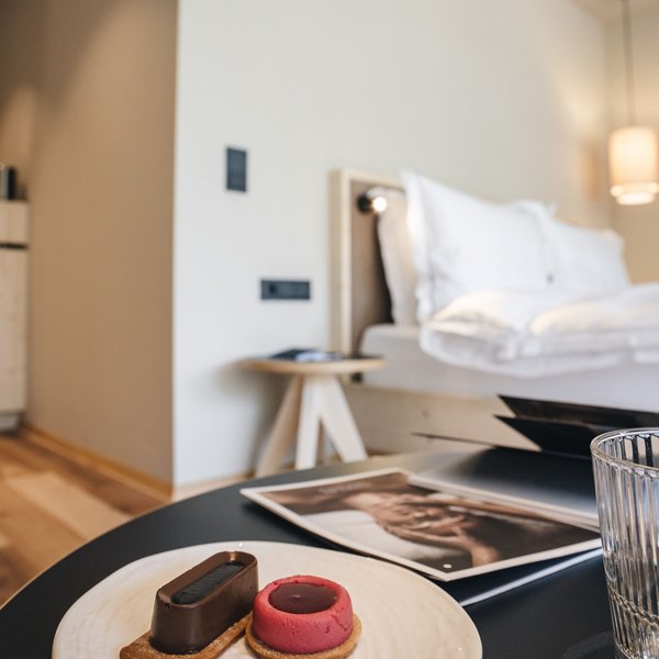 Romantischer Kurzurlaub für Verliebte – Sensoria Dolomites Zwei kleine Desserts auf einem Teller in elegantem Hotelzimmer