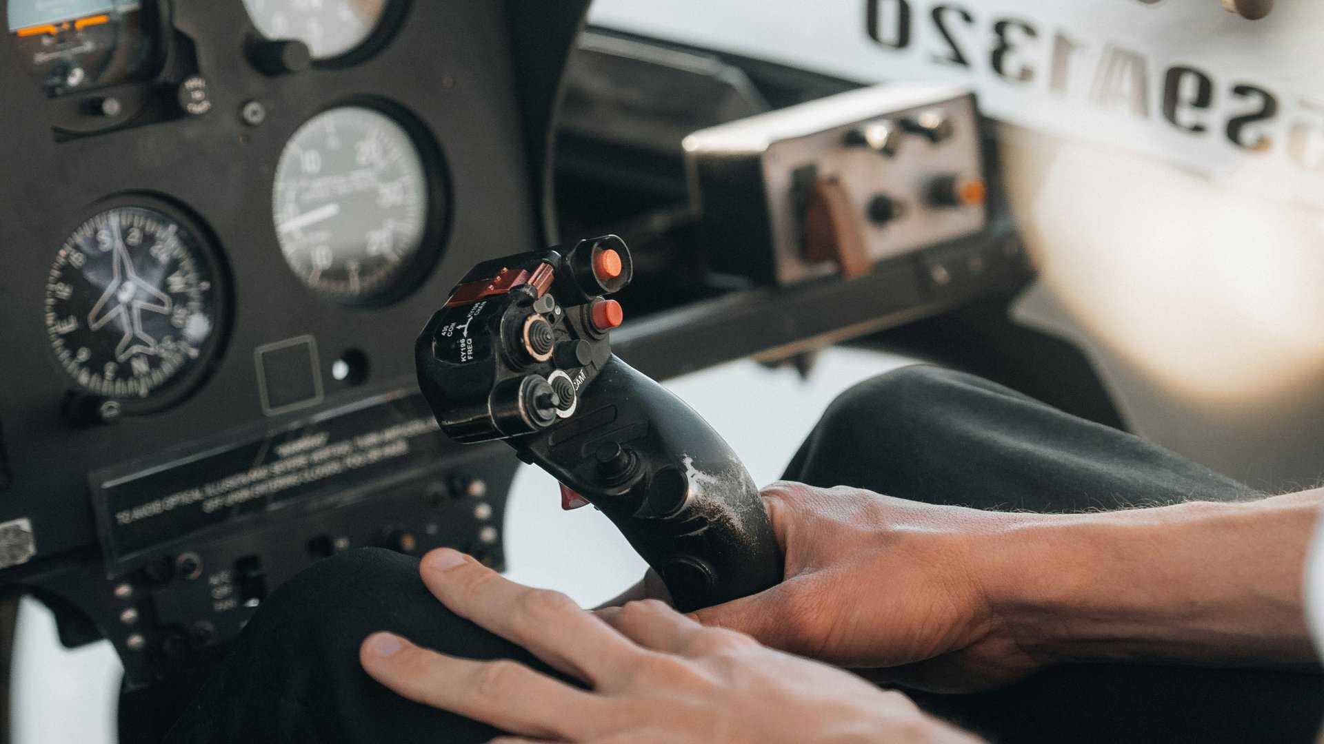Ein Helikopterflug in den Dolomiten – Augenblicke über den Gipfeln Hand hält Steuerknüppel im Flugzeugcockpit mit Instrumenten