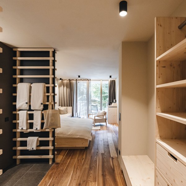 Sensoria Dolomites: Wellnesshotel in den Dolomiten Helles Hotelzimmer mit Holzfußboden und modernem minimalistischem Design